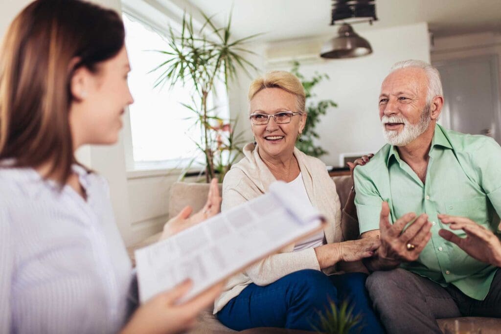 a senior couple sitting in their living room talking with an advisor