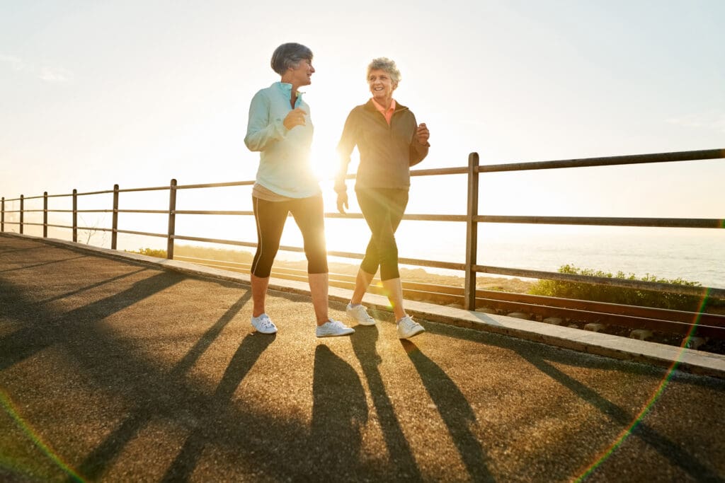 two senior women walking on path