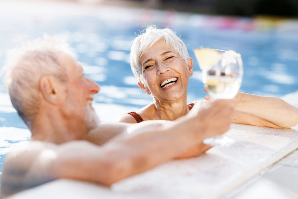 happy senior couple relaxing in pool