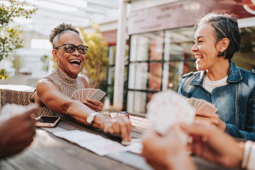 Senior women friends playing cards