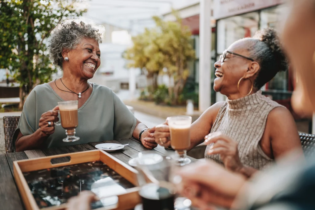 seniors holding drinks sitting at a table 
