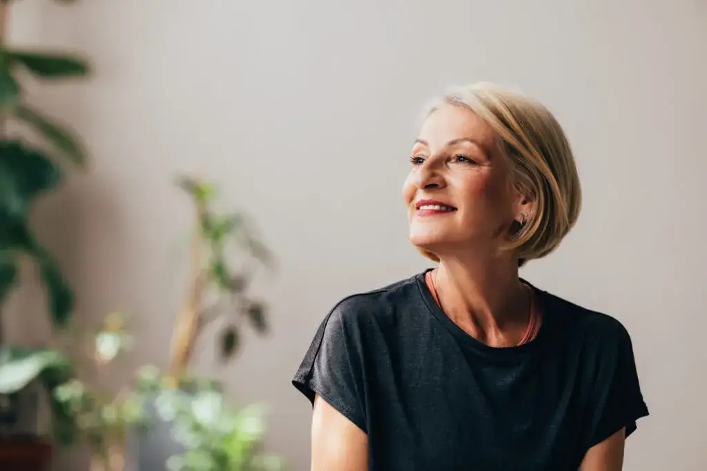 senior woman smiling and lookin in the distance while contemplating the value of planning ahead for senior living at The Winsberg at Green Cay in FL.