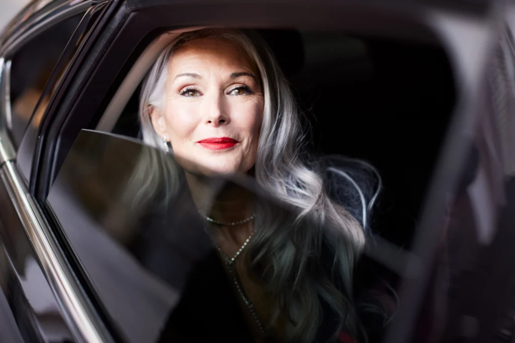 A senior woman looking out of car window thinking about seeking help for seniors moving and rightsizing for retirement at The Winsberg at Green Cay, a luxury retirement community in Delray Beach, FL.